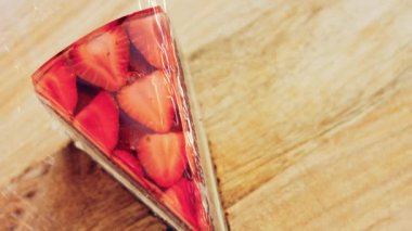 Çilek ve jöleli bir dilim pasta. Makro ve kaydırma atışı. Arka planda bir retro atmosfer var..