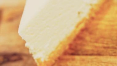 Frenk üzümlü bir dilim peynirli kek. Makro ve kaydırma atışı. Arka planda bir retro atmosfer var..