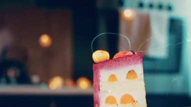 Çilekli, beyaz ve kırmızı kirazlı bir dilim pasta. Pastanın özel bir kubbesi var. Makro ve kaydırma atışı. Arka planda bir retro atmosfer var..