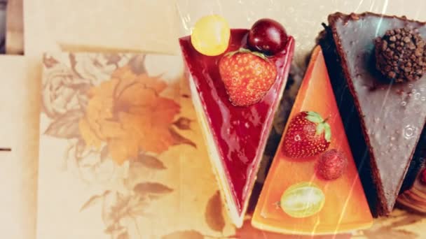 几片白色和红色的草莓和樱桃蛋糕和巧克力放在一个打开的盒子里 宏观和滑翔机射击 背景是一种复古的气氛 — 图库视频影像