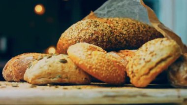 Ahşap masada farklı türde taze ekmek. Kahverengi arka planda münferit bir ekmek çeşidi. Kaydırıcı atışı.