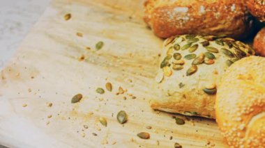 Ahşap masada farklı türde taze ekmek. Kahverengi arka planda münferit bir ekmek çeşidi. Kaydırıcı atışı.