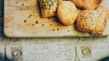 Ahşap masada farklı türde taze ekmek. Kahverengi arka planda münferit bir ekmek çeşidi. Kaydırıcı atışı.