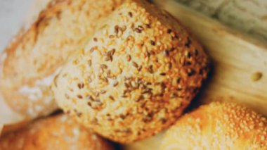 Ahşap masada farklı türde taze ekmek. Kahverengi arka planda münferit bir ekmek çeşidi. Kaydırıcı atışı.