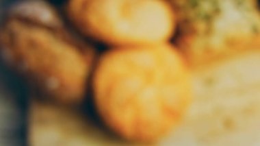 Ahşap masada farklı türde taze ekmek. Kahverengi arka planda münferit bir ekmek çeşidi. Kaydırıcı atışı.