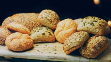 Ahşap masada farklı türde taze ekmek. Kahverengi arka planda münferit bir ekmek çeşidi. Kaydırıcı atışı.