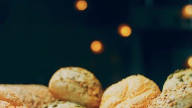 Ahşap masada farklı türde taze ekmek. Kahverengi arka planda münferit bir ekmek çeşidi. Kaydırıcı atışı.