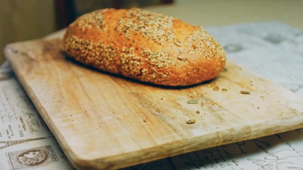 新鲜烘焙的面包和种子 背景是一个浪漫的随行人员1 背景是棕色的孤立的面包 滑翔机射击 — 图库视频影像