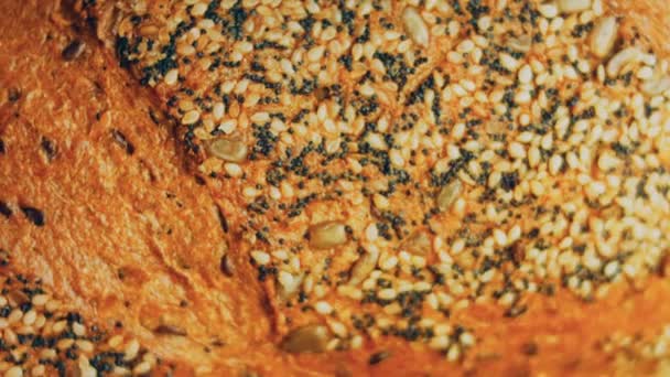 新鲜烘焙的面包和种子 背景是一个浪漫的随行人员1 背景是棕色的孤立的面包 滑翔机射击 — 图库视频影像