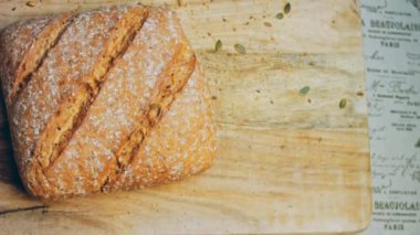 Çizgileri olan taze pişmiş kare ekmek. Arka planda romantik bir ortam var. Kahverengi arka planda münferit bir ekmek çeşidi. Kaydırıcı atışı.