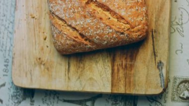 Çizgileri olan taze pişmiş kare ekmek. Arka planda romantik bir ortam var. Kahverengi arka planda münferit bir ekmek çeşidi. Kaydırıcı atışı.