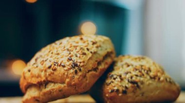 İki taze pişmiş kare ekmek ve tohum. Arka planda romantik bir ortam var. Makro ve sürgülü atış.