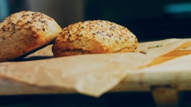 İki taze pişmiş kare ekmek ve tohum. Arka planda romantik bir ortam var. Makro ve sürgülü atış.