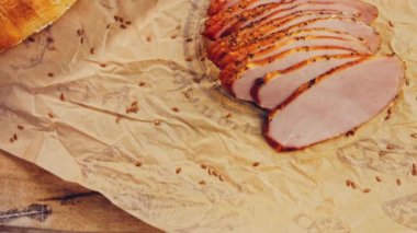 Fransız ekmeğiyle dilimlenmiş domuz filetosu. Sosis retro-stil yemek tepsisinde ve yemek kağıdında. Yavaş çekim kaydırağın üzerinde. Taze marul yaprakları da kullanıyoruz..