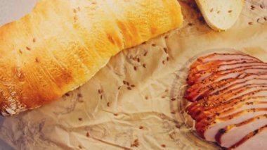 Fransız ekmeğiyle dilimlenmiş domuz filetosu. Sosis retro-stil yemek tepsisinde ve yemek kağıdında. Yavaş çekim kaydırağın üzerinde. Taze marul yaprakları da kullanıyoruz..