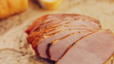 Fransız ekmeğiyle dilimlenmiş domuz filetosu. Sosis retro-stil yemek tepsisinde ve yemek kağıdında. Yavaş çekim kaydırağın üzerinde. Taze marul yaprakları da kullanıyoruz..