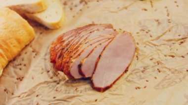 Fransız ekmeğiyle dilimlenmiş domuz filetosu. Sosis retro-stil yemek tepsisinde ve yemek kağıdında. Yavaş çekim kaydırağın üzerinde. Taze marul yaprakları da kullanıyoruz..