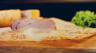 Fransız ekmeğiyle dilimlenmiş domuz filetosu. Sosis retro-stil yemek tepsisinde ve yemek kağıdında. Yavaş çekim kaydırağın üzerinde. Taze marul yaprakları da kullanıyoruz..