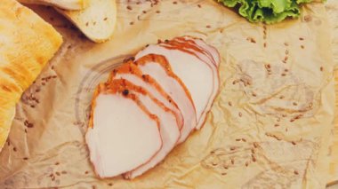 Fransız ekmeğiyle dilimlenmiş domuz filetosu. Sosis retro-stil yemek tepsisinde ve yemek kağıdında. Yavaş çekim kaydırağın üzerinde. Taze marul yaprakları da kullanıyoruz..