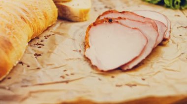 Fransız ekmeğiyle dilimlenmiş domuz filetosu. Sosis retro-stil yemek tepsisinde ve yemek kağıdında. Yavaş çekim kaydırağın üzerinde. Taze marul yaprakları da kullanıyoruz..