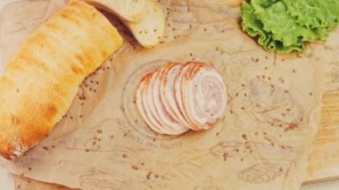 Fransız ekmeğiyle dilimlenmiş sosisli börek. Sosis retro-stil yemek tepsisinde ve yemek kağıdında. Yavaş çekim kaydırağın üzerinde. Taze marul yaprakları da kullanıyoruz..