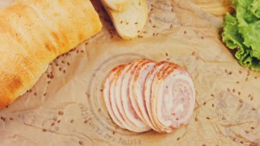 Fransız ekmeğiyle dilimlenmiş sosisli börek. Sosis retro-stil yemek tepsisinde ve yemek kağıdında. Yavaş çekim kaydırağın üzerinde. Taze marul yaprakları da kullanıyoruz..