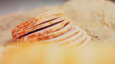 Fransız ekmeğiyle dilimlenmiş sosisli börek. Sosis retro-stil yemek tepsisinde ve yemek kağıdında. Yavaş çekim kaydırağın üzerinde. Taze marul yaprakları da kullanıyoruz..