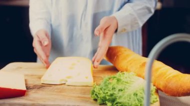 Kadın elinde delikli bir parça peynir tutuyor. Kaydırıcı peynir sunum sürecini kaydetti.