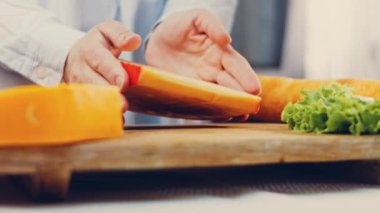 Kadın elinde delikli bir parça peynir tutuyor. Kaydırıcı peynir sunum sürecini kaydetti.