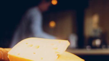 Retro-stil yemek tepsisinde delikleri olan peynir. Kaypak peynir sunum sürecini kaydetti. Arka planda Fransız ekmeği ve taze marul yaprakları var..