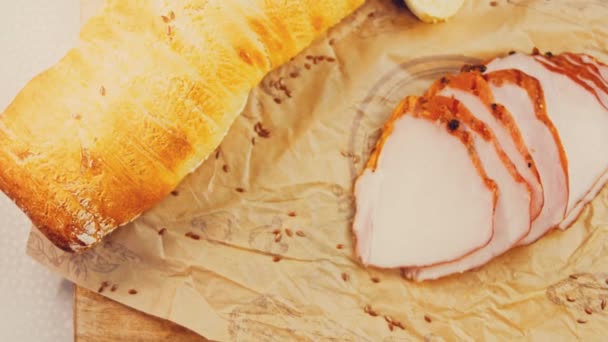 豚ヒレ肉をフランスのバゲットでスライスしたもの ソーセージはレトロスタイルのクッキングトレイと紙の上にあります スライダーでスローモーション撮影 新鮮なレタスの葉も使用 — ストック動画