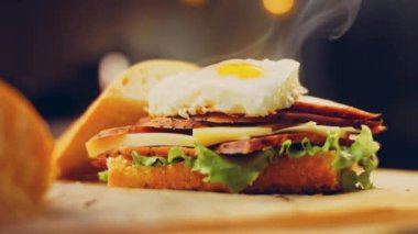 Fransız ekmeği, peynir, salata yaprakları ve sosisle sanvich 'in üzerinde kaynayan kalp şeklinde sahanda yumurta. Kaydırıcı atışı.