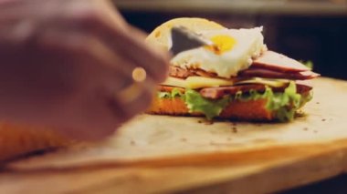 Fransız ekmeği, peynir, salata yaprakları ve sosisle sanvich 'in üzerinde kaynayan kalp şeklinde sahanda yumurta. Kaydırıcı atışı.