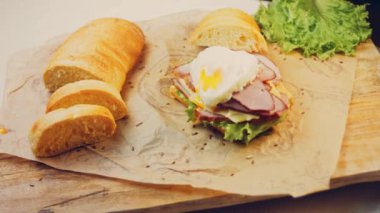 Fransız ekmeği, peynir, salata yaprakları ve sosisle sanvich 'in üzerinde kaynayan kalp şeklinde sahanda yumurta. Kaydırıcı atışı.