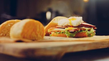 Fransız ekmeği, peynir, salata yaprakları ve sosisle sanvich 'in üzerinde kaynayan kalp şeklinde sahanda yumurta. Kaydırıcı atışı.