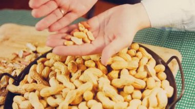 Kadın retro tepsisindeki fıstıkları soyuyor. Makro kaydırma atışı.