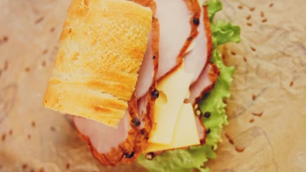 フランスのバゲットとサンドイッチ チーズ レタスとソーセージ スライダー撮影 背景にはレトロなベーキングトレイと調理紙があります — ストック動画