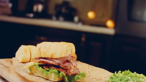 三明治配法式面包 生菜和香肠 滑翔机射击后面是一个复古烤盘和烹调用纸 — 图库视频影像