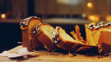 Dilimlenmiş çikolatalı panettone. Arka planda kağıttan yapılmış Paskalya tavşanları var. Makro ve sürgülü atış.