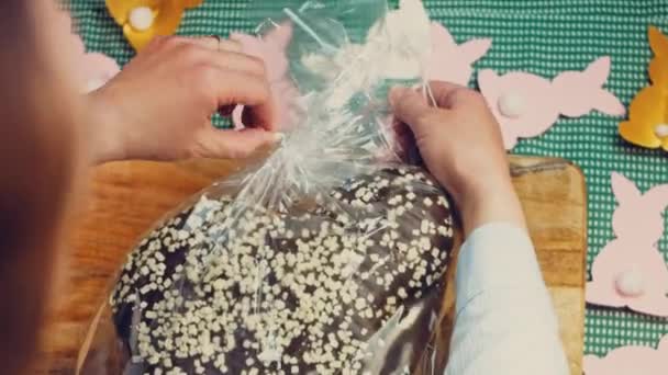 Женщина Распаковывает Шоколадный Панеттон Заднем Плане Пасхальные Кролики Бумаги Макро — стоковое видео