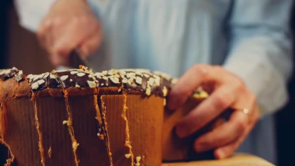 那女人用刀切巧克力蛋糕 背景是由纸张制成的复活节大扫除 宏观和滑块射击 — 图库视频影像