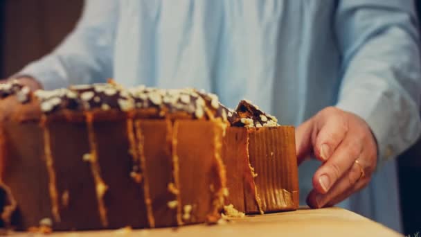 女性はナイフでチョコレートケーキをカットします 背景には 紙で作られたイースターのパージがあります マクロ撮影とスライダー撮影 — ストック動画
