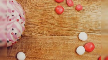 Tatlılarla süslenmiş pembe çörekler. Makro ve kaydırma atışı. Tatlı, jöleli tatlılar. Fırın ve yemek konsepti. Çeşitli renkli çörekler. Çikolata, pembe, mavi çörekler 4K, UHD.