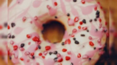 Tatlılarla süslenmiş pembe çörekler. Makro ve kaydırma atışı. Tatlı, jöleli tatlılar. Fırın ve yemek konsepti. Çeşitli renkli çörekler. Çikolata, pembe, mavi çörekler 4K, UHD.