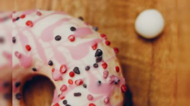 Tatlılarla süslenmiş pembe çörekler. Makro ve kaydırma atışı. Tatlı, jöleli tatlılar. Fırın ve yemek konsepti. Çeşitli renkli çörekler. Çikolata, pembe, mavi çörekler 4K, UHD.