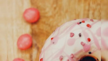 Tatlılarla süslenmiş pembe çörekler. Makro ve kaydırma atışı. Tatlı, jöleli tatlılar. Fırın ve yemek konsepti. Çeşitli renkli çörekler. Çikolata, pembe, mavi çörekler 4K, UHD.