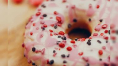 Tatlılarla süslenmiş pembe çörekler. Makro ve kaydırma atışı. Tatlı, jöleli tatlılar. Fırın ve yemek konsepti. Çeşitli renkli çörekler. Çikolata, pembe, mavi çörekler 4K, UHD.