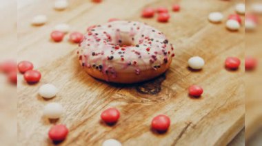 Tatlılarla süslenmiş pembe çörekler. Makro ve kaydırma atışı. Tatlı, jöleli tatlılar. Fırın ve yemek konsepti. Çeşitli renkli çörekler. Çikolata, pembe, mavi çörekler 4K, UHD.