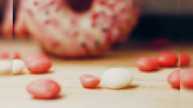 Tatlılarla süslenmiş pembe çörekler. Makro ve kaydırma atışı. Tatlı, jöleli tatlılar. Fırın ve yemek konsepti. Çeşitli renkli çörekler. Çikolata, pembe, mavi çörekler 4K, UHD.