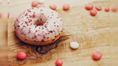 Tatlılarla süslenmiş pembe çörekler. Makro ve kaydırma atışı. Tatlı, jöleli tatlılar. Fırın ve yemek konsepti. Çeşitli renkli çörekler. Çikolata, pembe, mavi çörekler 4K, UHD.